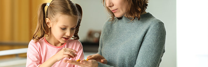 Young girl looking at medication with her mother